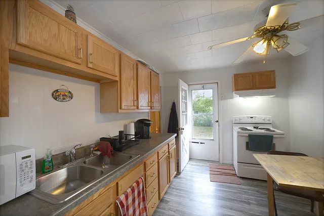 a kitchen with kitchen island granite countertop a sink cabinets and stainless steel appliances