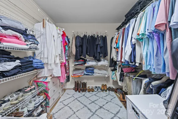 a view of walk in closet with clothes