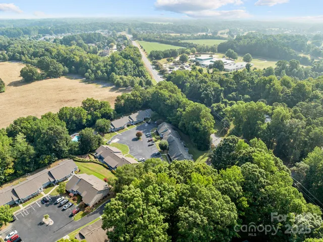 an aerial view of a houses with a lush green hillside