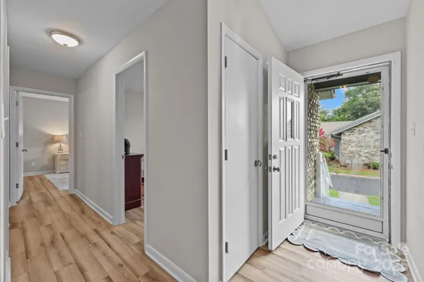 a view of a hallway with wooden floor and a bedroom