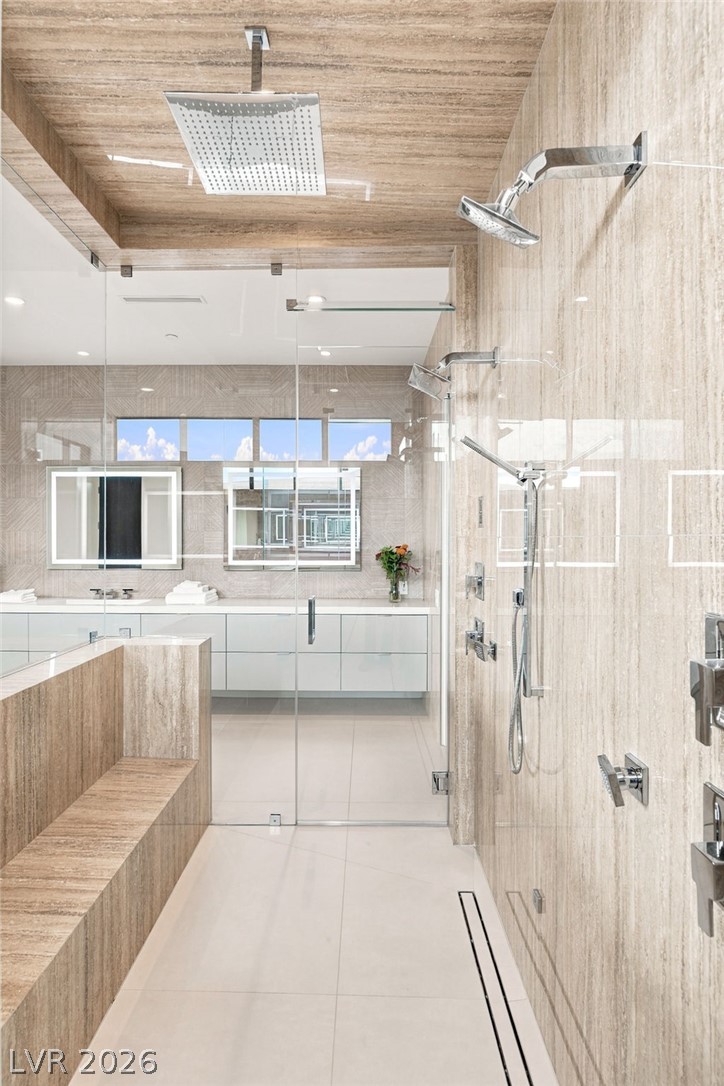 677 Overlook Rim Drive Henderson, NV 89012 - Photo 39 of 97 Floor-to-ceiling stone tile finishes and a glass enclosure frame this modern walk-in shower.