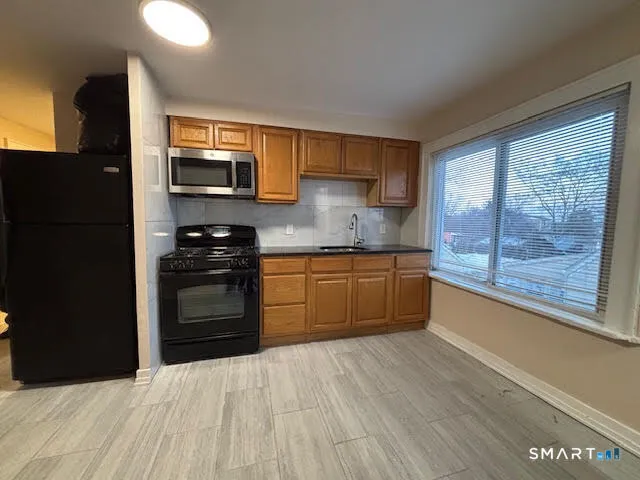a kitchen with stainless steel appliances granite countertop a stove a sink and a refrigerator
