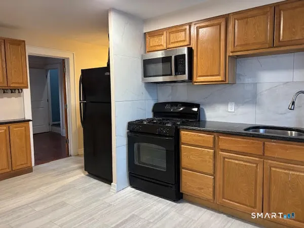 a kitchen with stainless steel appliances granite countertop a refrigerator stove and microwave