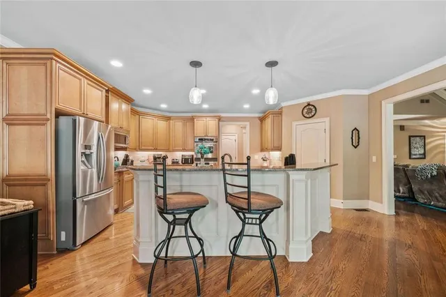 a kitchen with stainless steel appliances granite countertop a refrigerator sink and cabinets