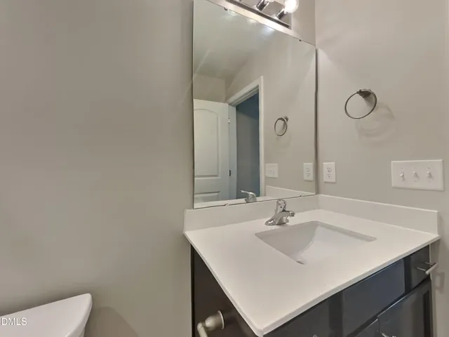 a bathroom with a sink toilet and mirror