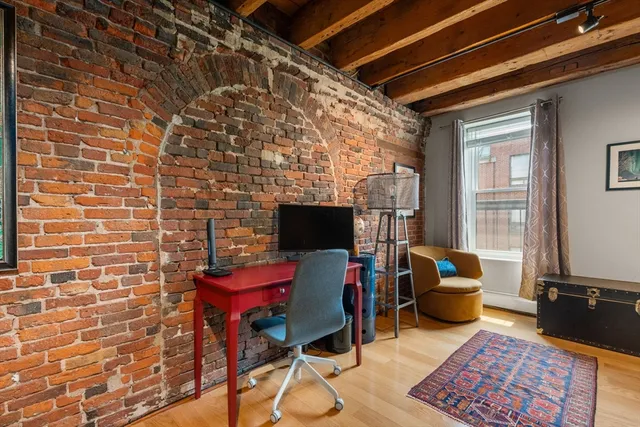 a view of a workspace with furniture and a window