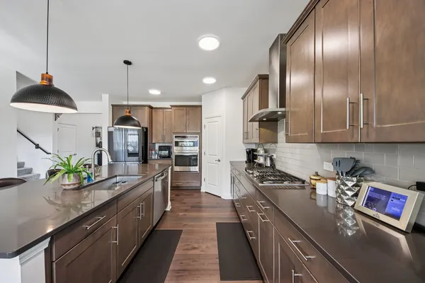 a kitchen with stainless steel appliances granite countertop a sink a stove and a refrigerator