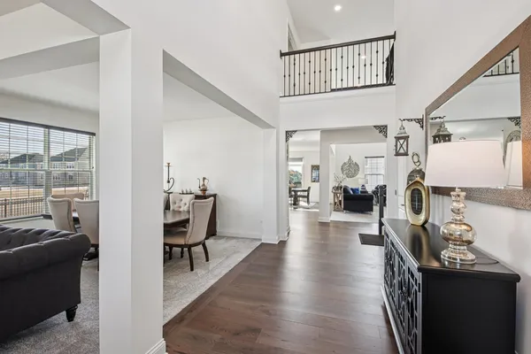 a view of a hallway with dining room and wooden floor
