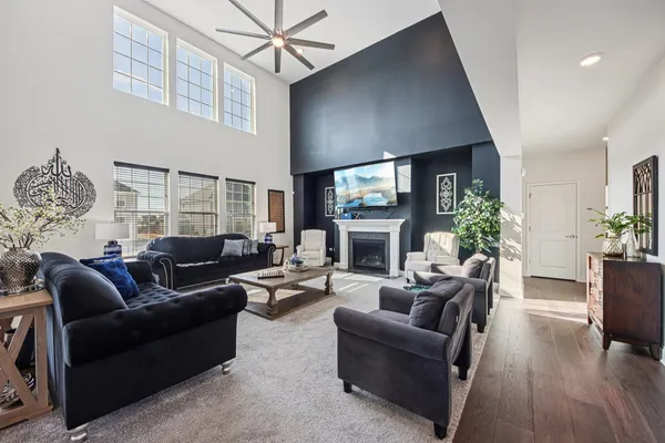 a living room with furniture a fireplace and a ceiling fan