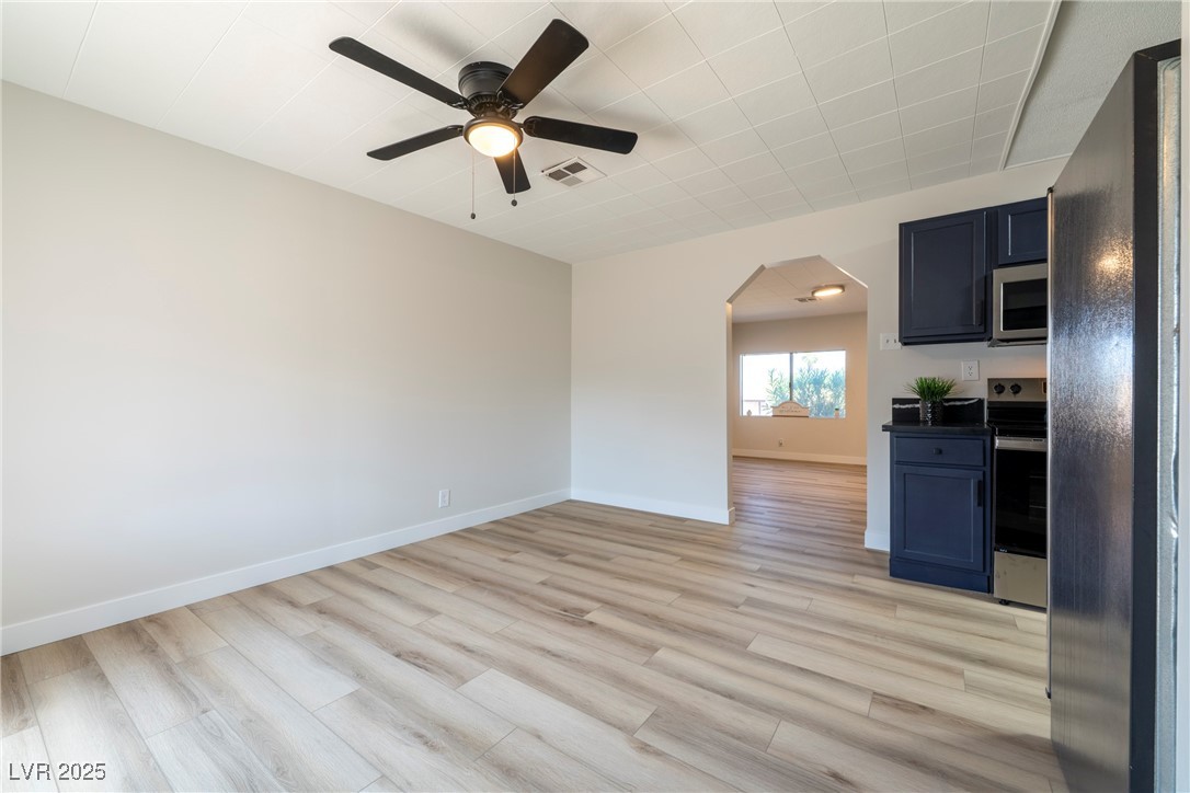238 Kansas Avenue Henderson, NV 89015 - Photo 11 of 61 Empty room with light wood-type flooring, a ceiling fan, and arched walkways