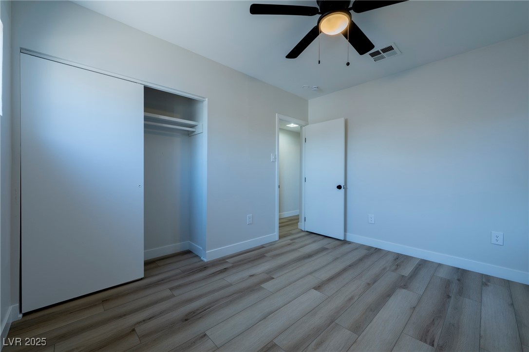 238 Kansas Avenue Henderson, NV 89015 - Photo 22 of 61 Unfurnished bedroom with light wood finished floors, a ceiling fan, and a closet