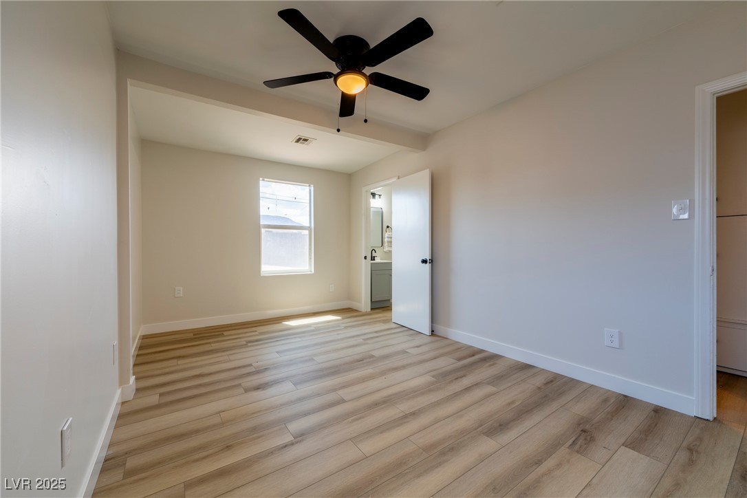 238 Kansas Avenue Henderson, NV 89015 - Photo 26 of 61 Unfurnished bedroom with light wood-type flooring, a ceiling fan, and ensuite bathroom
