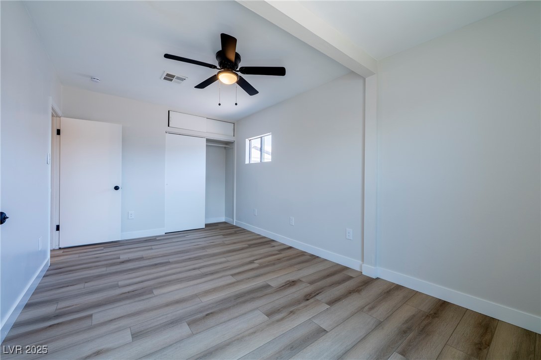 238 Kansas Avenue Henderson, NV 89015 - Photo 36 of 61 Unfurnished bedroom featuring light wood-style flooring, ceiling fan, a closet, and beamed ceiling