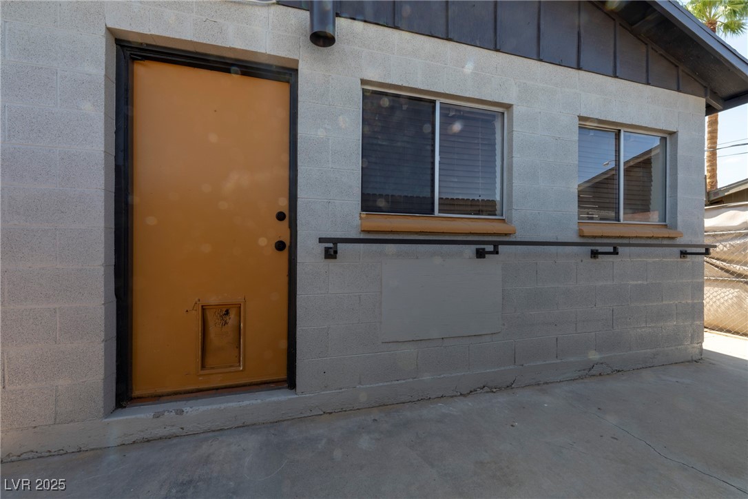 238 Kansas Avenue Henderson, NV 89015 - Photo 43 of 61 View of exterior entry featuring concrete block siding and board and batten siding