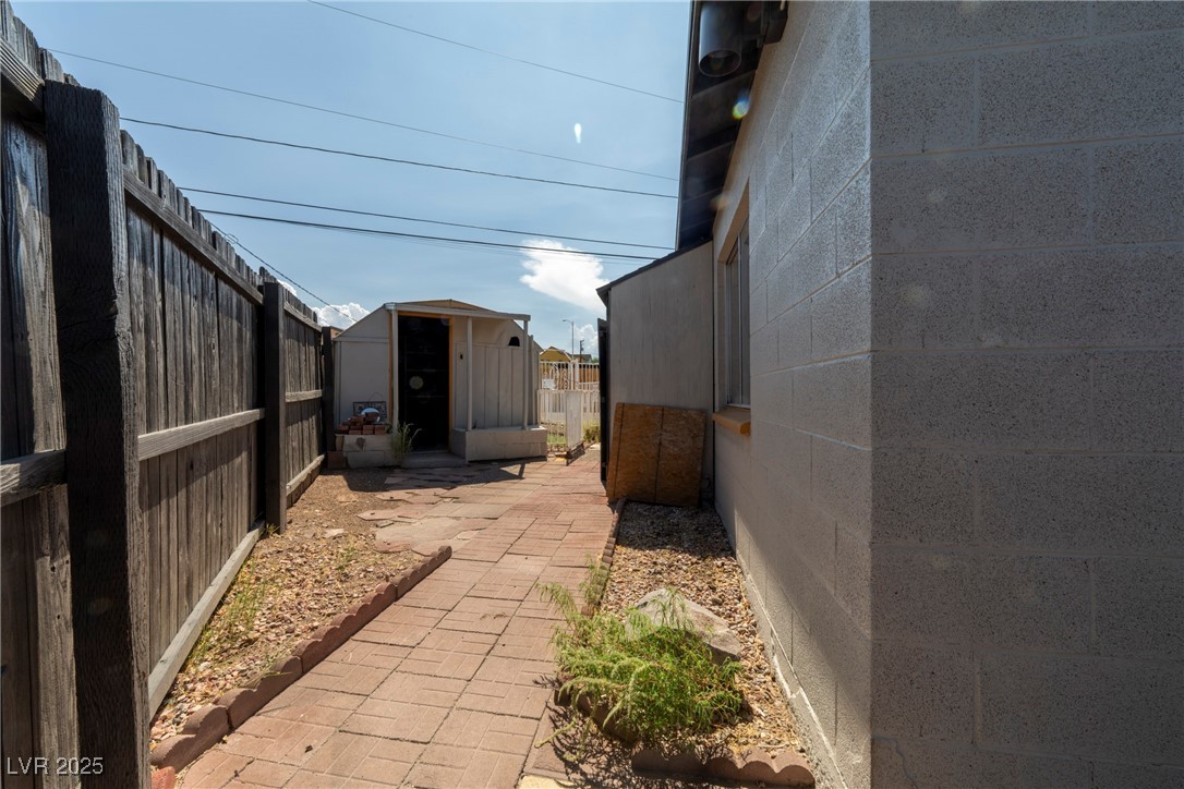 238 Kansas Avenue Henderson, NV 89015 - Photo 44 of 61 View of side of home featuring concrete block siding, a fenced backyard, and a storage shed