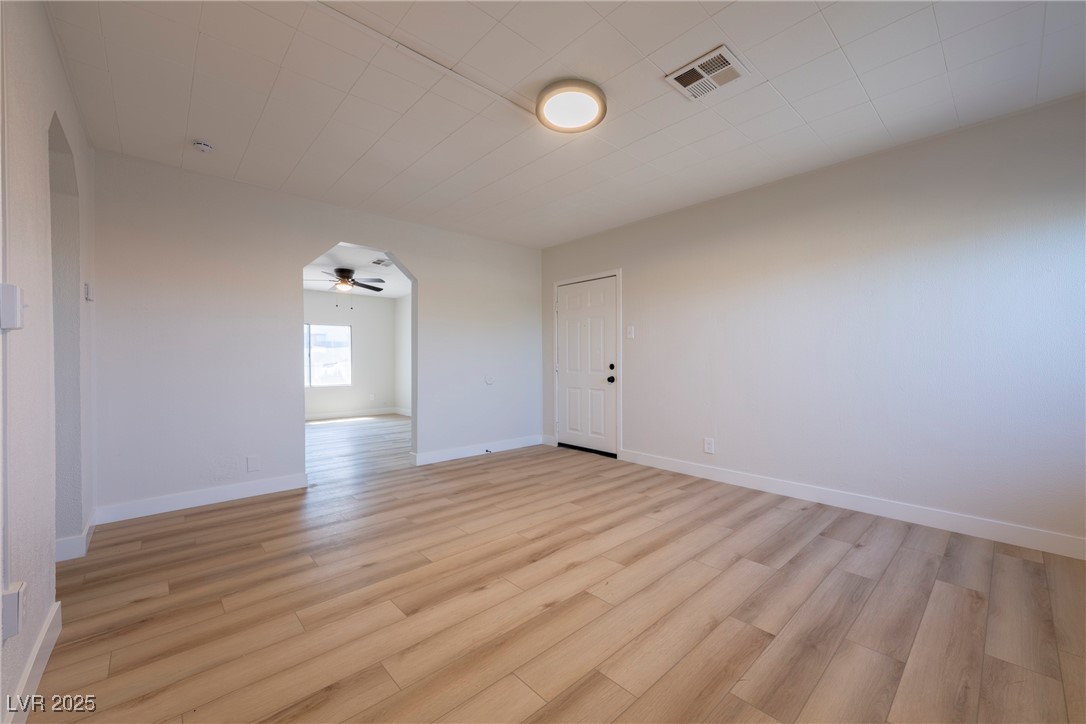 238 Kansas Avenue Henderson, NV 89015 - Photo 6 of 61 Empty room with light wood finished floors, arched walkways, and a ceiling fan