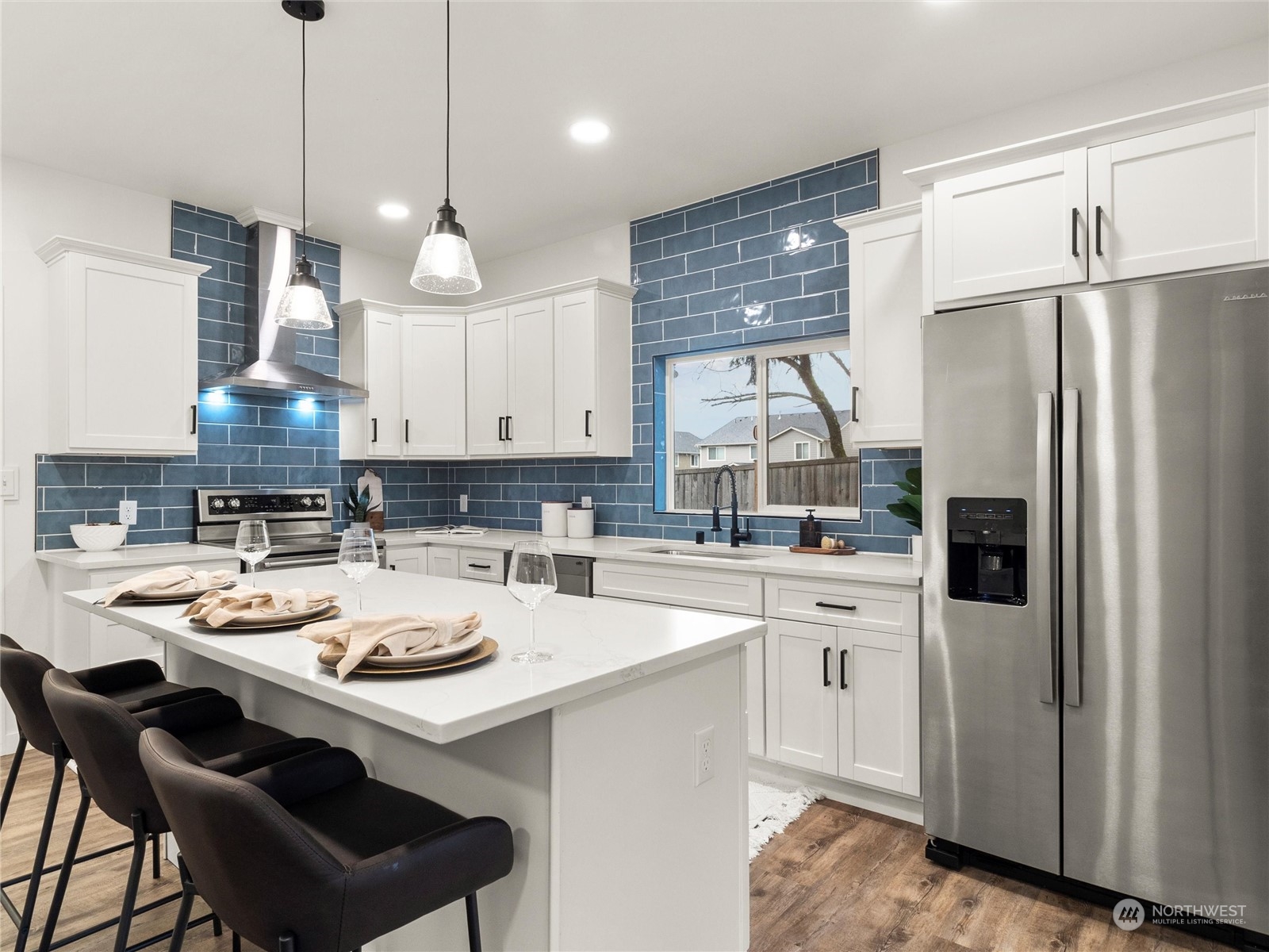 9331 Cullens Road Southeast Yelm, WA 98597 - Photo 7 of 28 a kitchen with a sink a stove a refrigerator and white cabinets