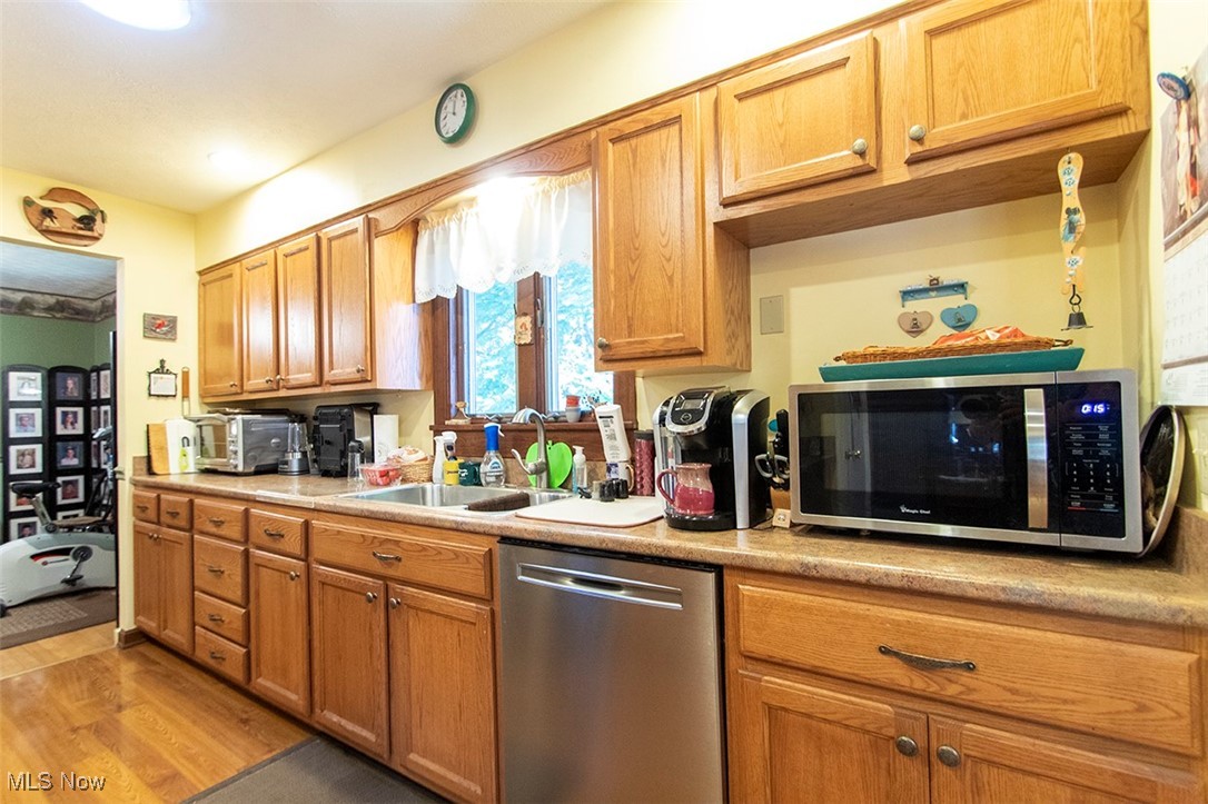 20749 Albion Road Strongsville, OH 44149 - Photo 11 of 35 Kitchen featuring a sink, light wood-style floors, appliances with stainless steel finishes, brown cabinetry, and light countertops