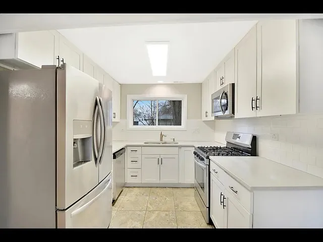 a kitchen with stainless steel appliances a refrigerator sink and cabinets