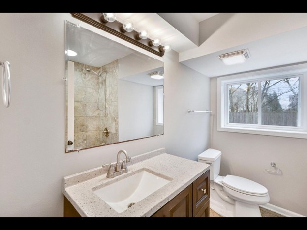 23519 North Field Road Lake Zurich, IL 60047 - Photo 9 of 14 a bathroom with a sink toilet a mirror and window