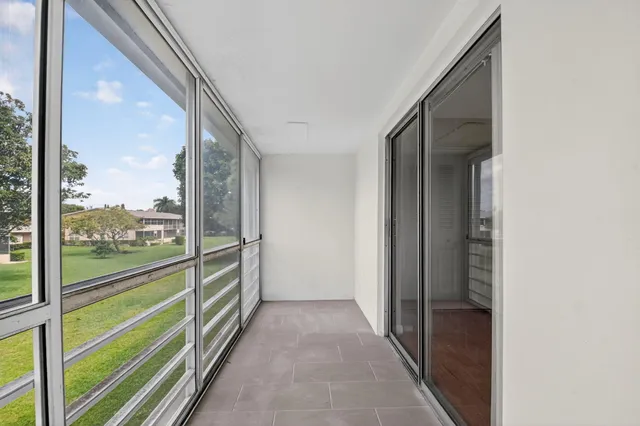 a view of a house with a big yard and palm trees