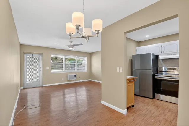 a view of a kitchen with a sink wooden cabinets and a refrigerator