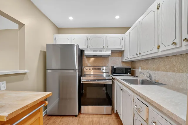 a kitchen with stainless steel appliances a refrigerator sink and cabinets