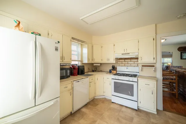 a kitchen with white cabinets and white appliances