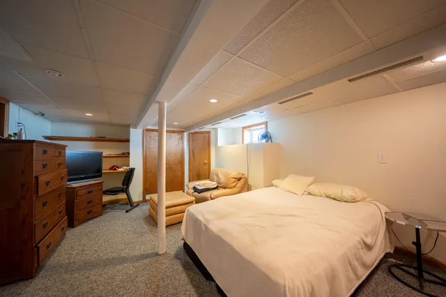 a bedroom with a bed tv and wooden floor