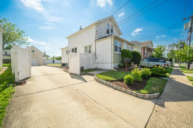 a front view of a house with a yard and potted plants