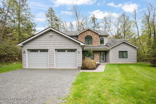 a front view of a house with yard and garage
