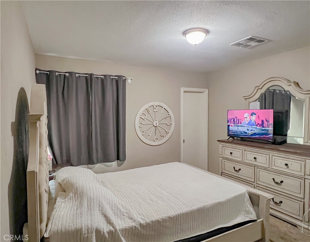 3013 Cornell Street Bakersfield, CA 93305 - Photo 11 of 20 a bedroom with a bed and a flat screen tv