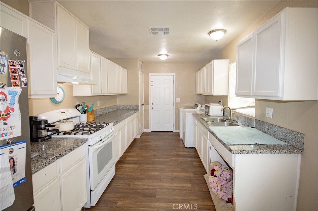 3013 Cornell Street Bakersfield, CA 93305 - Photo 7 of 20 a large kitchen with stainless steel appliances granite countertop a lot of counter space and wooden floor