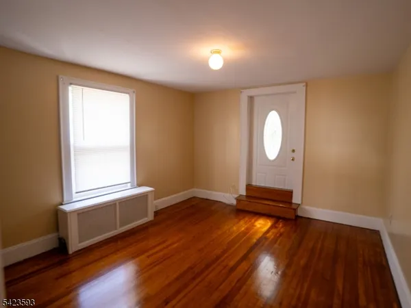 a view of a room with wooden floor and window