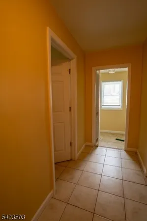 a view of an empty room with window and bathroom