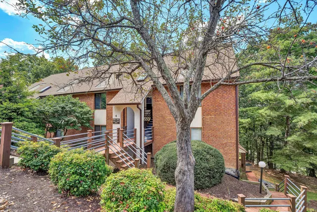 a front view of a house with a tree