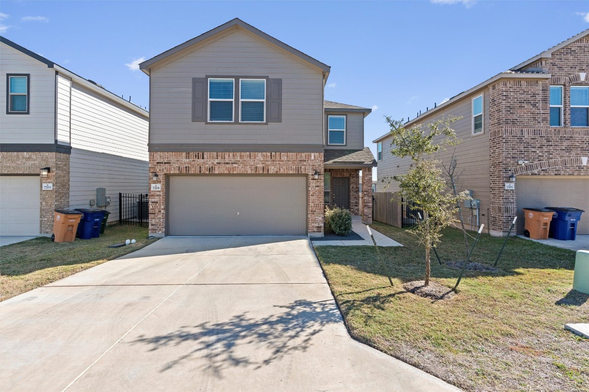 View of front of house with brick siding, concrete driveway, and an attached garage