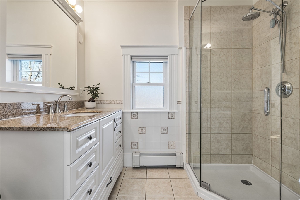424 Brook Road Milton, MA 02186 - Photo 17 of 41 a bathroom with a granite countertop sink a toilet a mirror and shower