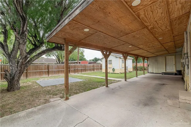 a view of a house with backyard and a trees