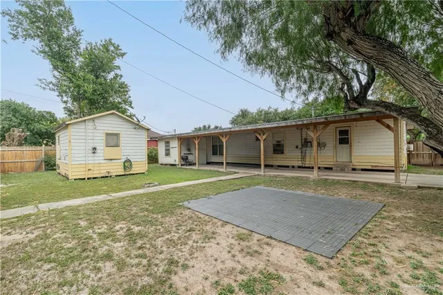 a view of a yard in front of a house with a large tree