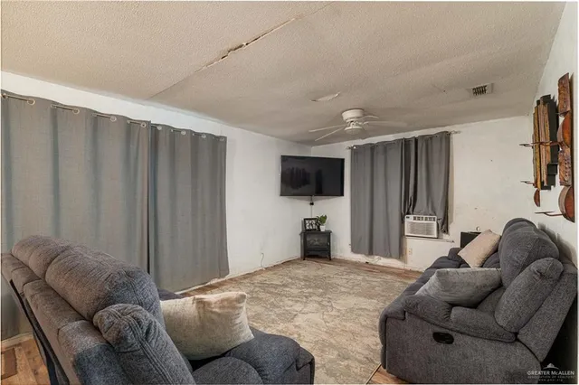 a living room with furniture a flat screen tv and a window