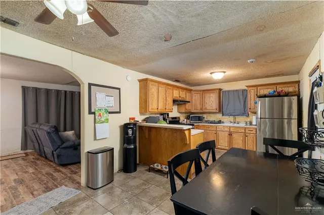 a kitchen with refrigerator and chairs