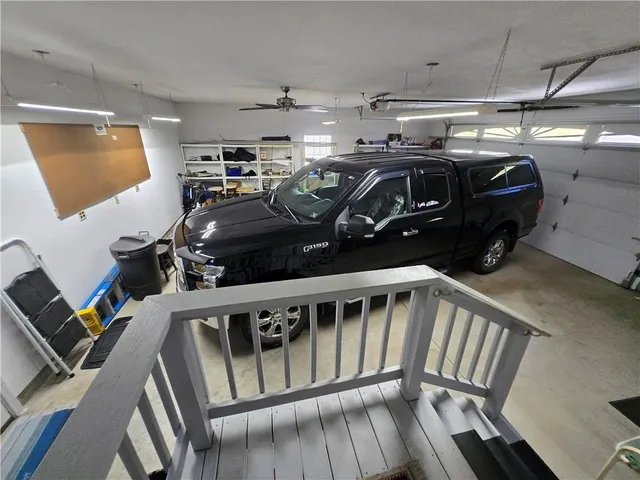 a kitchen with granite countertop a refrigerator a sink dishwasher a stove and white cabinets with wooden floor