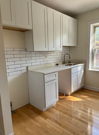 a kitchen with a sink cabinets and a window