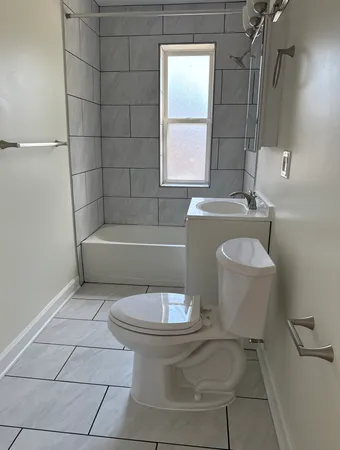 a bathroom with a sink a toilet a mirror and bathtub