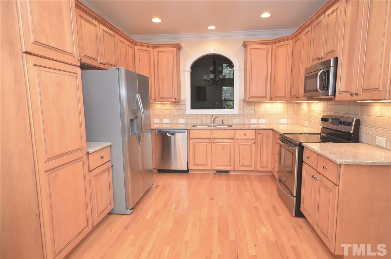 1843 Middlebrook Drive Raleigh, NC 27615 - Photo 5 of 13 a kitchen with stainless steel appliances granite countertop a refrigerator a stove top oven and white cabinets with wooden floor