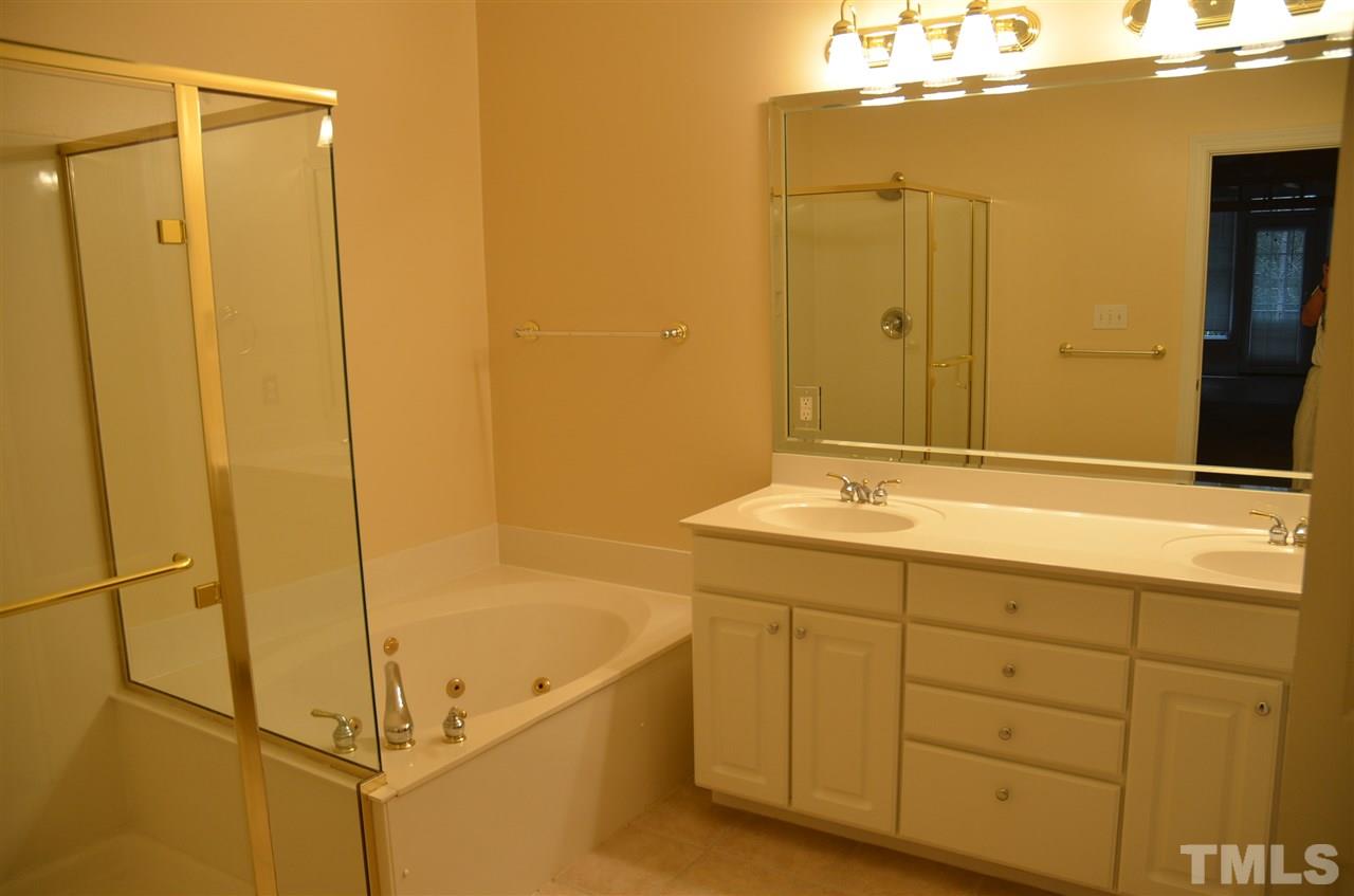 1843 Middlebrook Drive Raleigh, NC 27615 - Photo 9 of 13 a bathroom with a granite countertop sink a mirror and a bathtub