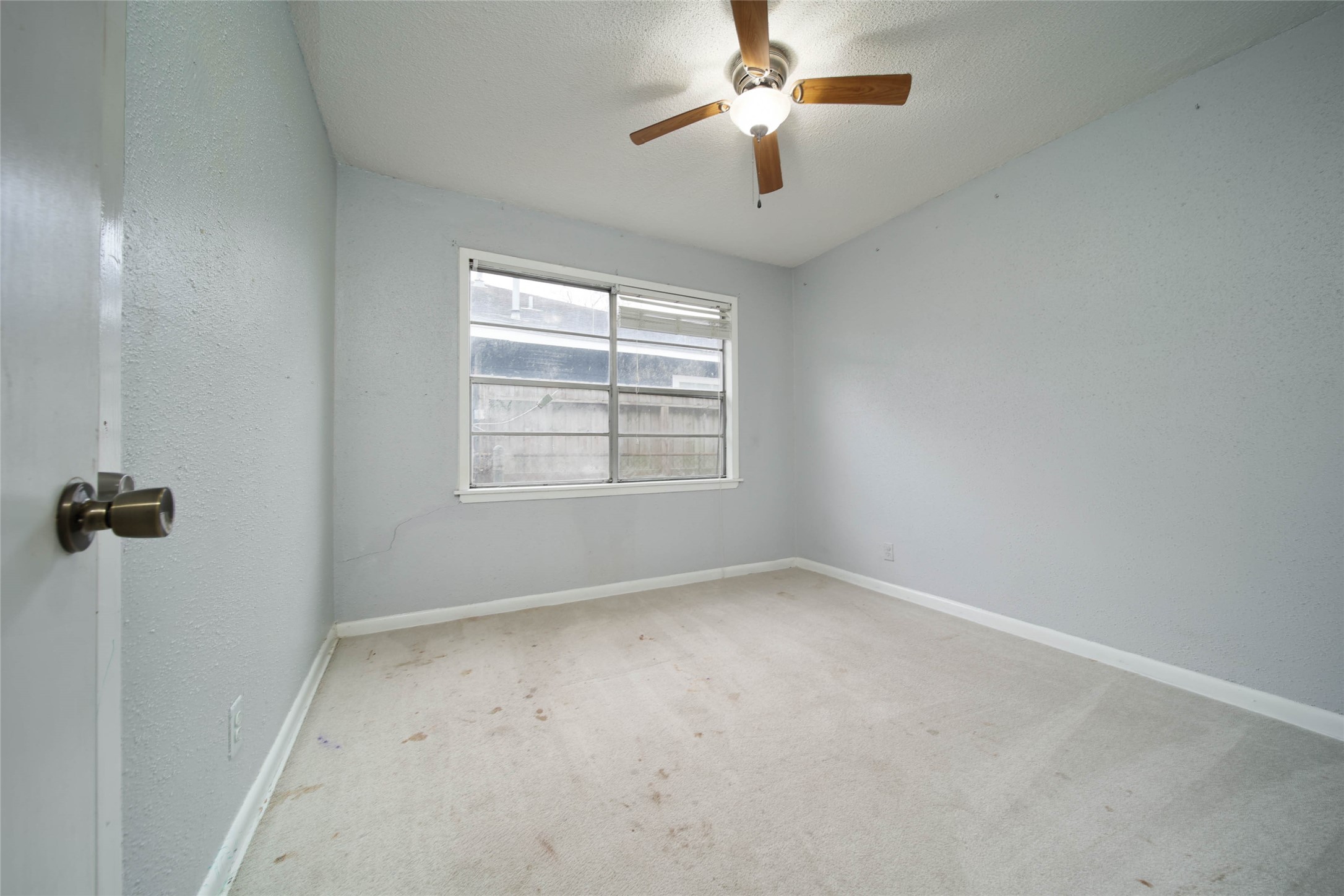 8718 Pattibob Street Houston, TX 77029 - Photo 13 of 14 en empty room with windows and ceiling fan