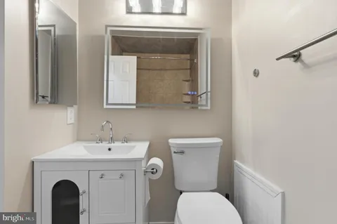 a bathroom with a toilet sink and mirror