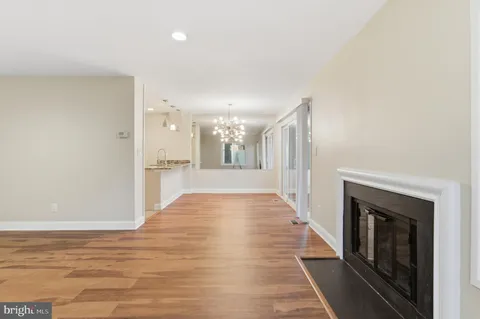 a view of a hallway with wooden floor and a fireplace
